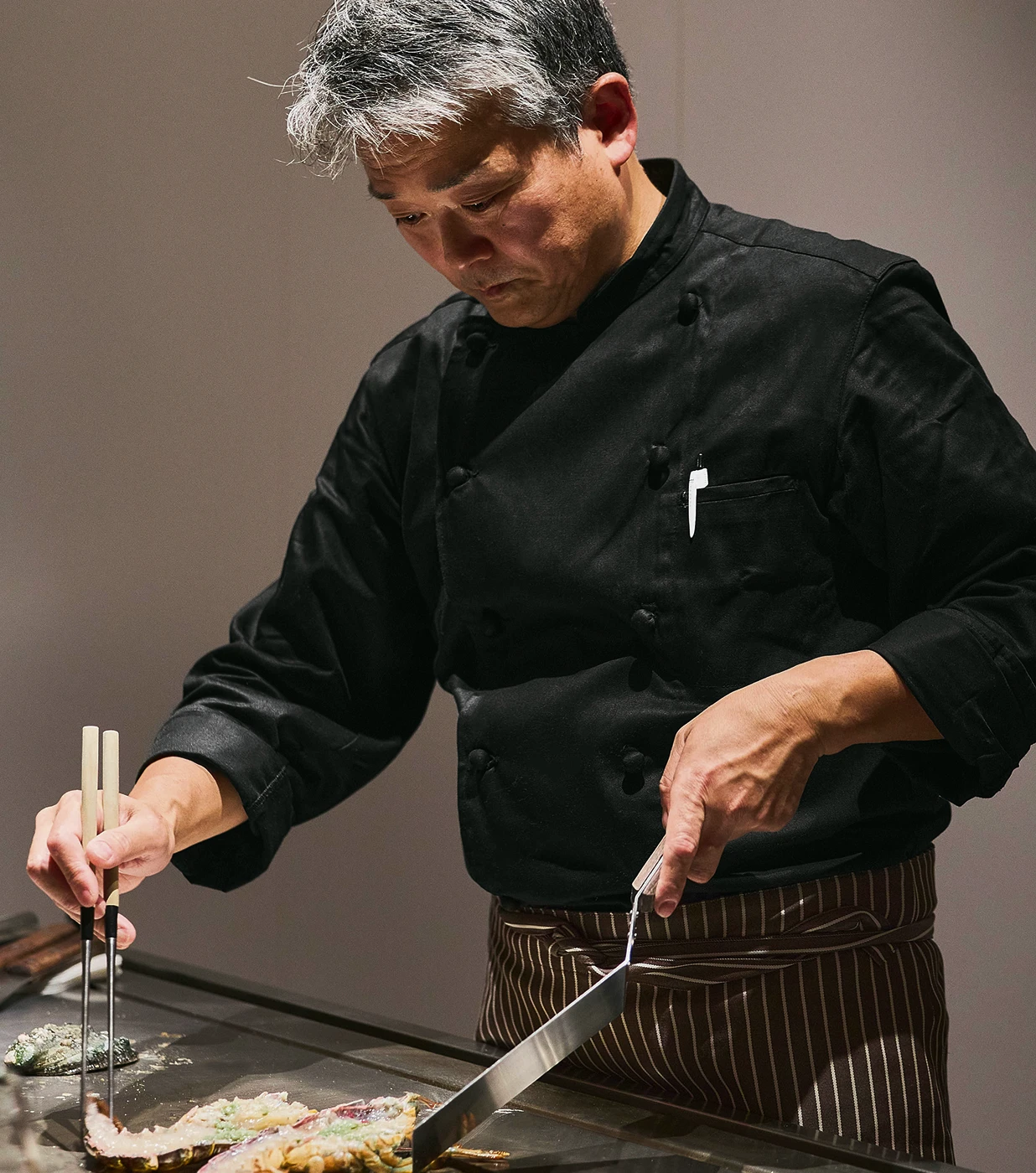 鉄板で丁寧に料理を仕上げるシェフの手元