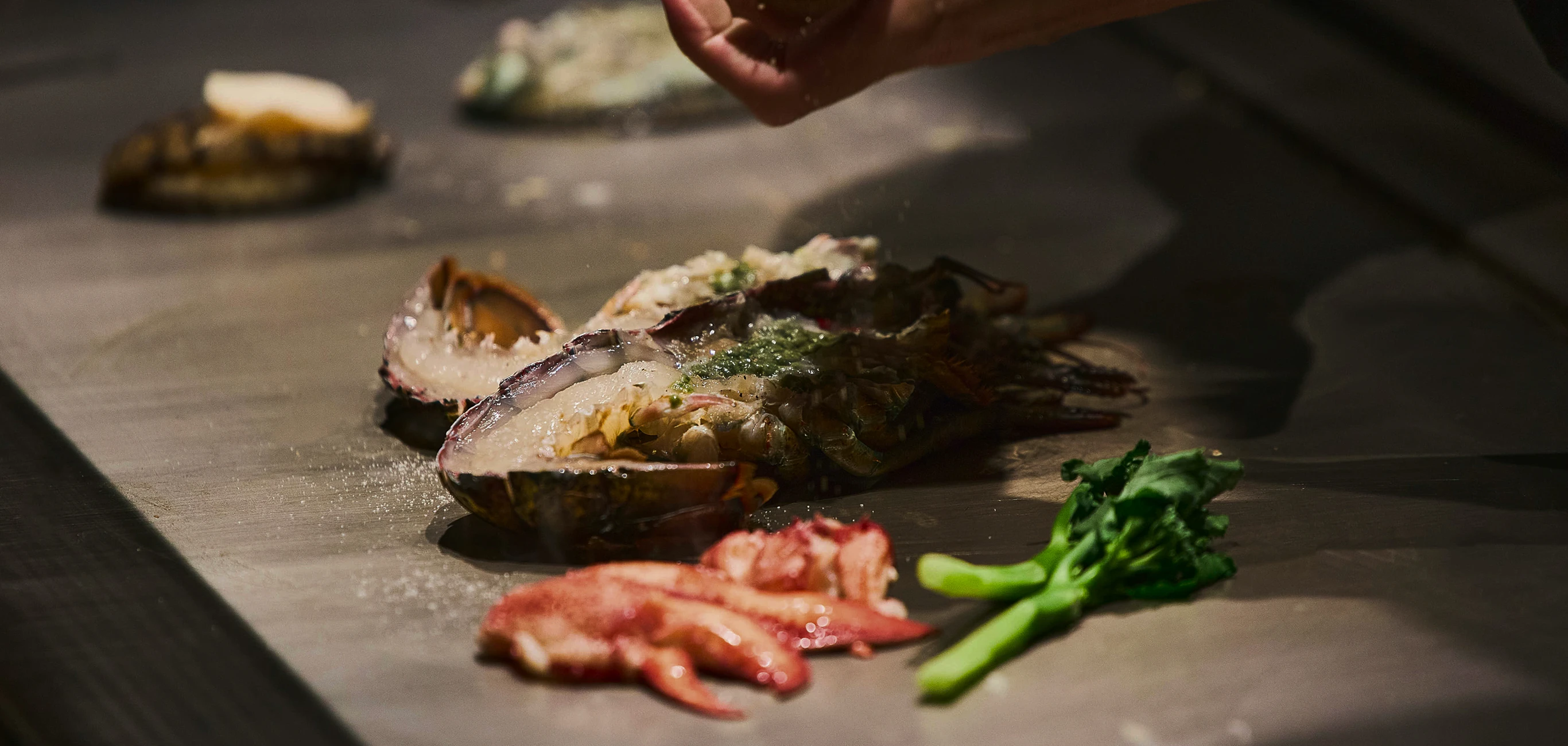 鉄板で焼き上げられる伊勢海老の調理シーン